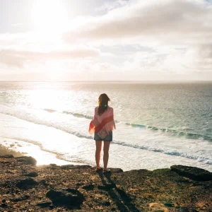 femme-regardant-la-mer-au-coucher-du-soleil